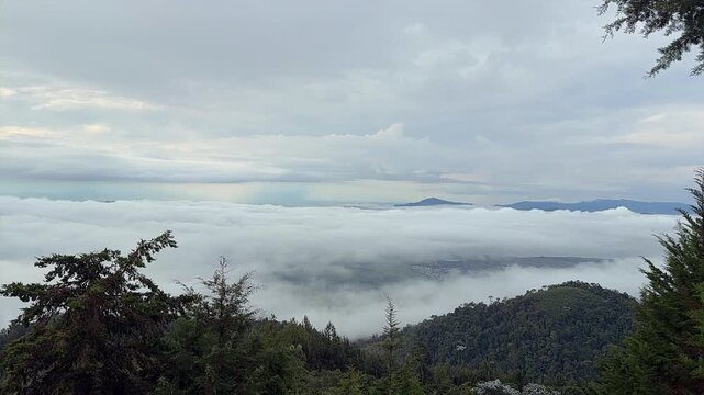 time-lapse aerial view of mountains and valley covered by thick morning fog and clouds