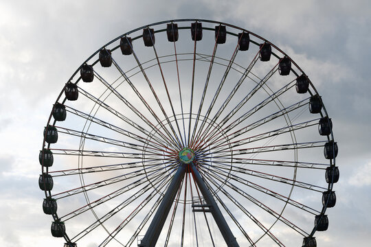 Silhouette of a Ferris Wheel Against an Early Morning Cloudy Sky