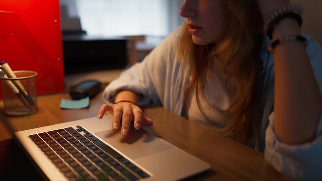Focused teenage girl working on a computer during a study session at home. Concentration, attention, learning, academic productivity and school education concept.