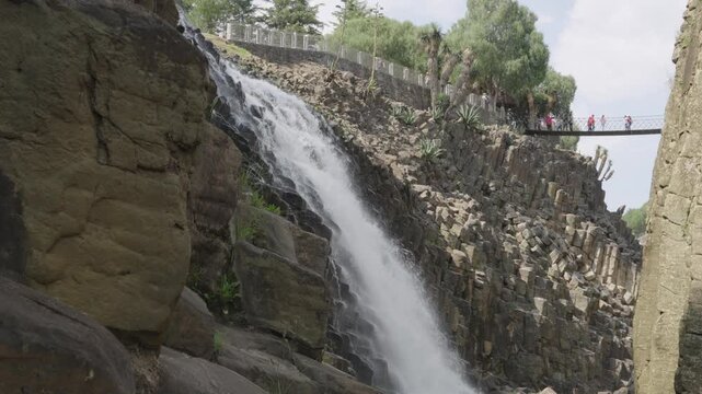 Majestic waterfall cascading down geometric basalt rock formations in huasca de ocampo, mexico