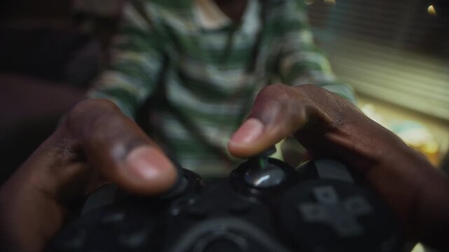 African American male teenager reaching for gamepad on messy desk and playing video game, extreme close up POV shot. Video is suitable for gaming ads or screen addiction awareness campaigns