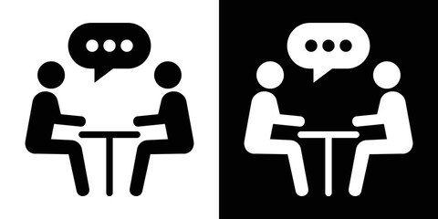 Flat vector symbol of two stick figures seated at a table communicating with a chat bubble, representing a one-on-one discussion or client meeting.