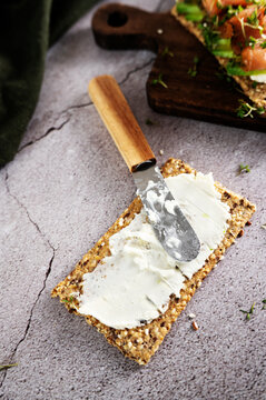 Crunchy crispbread with a cream cheese swirl and a table knife.