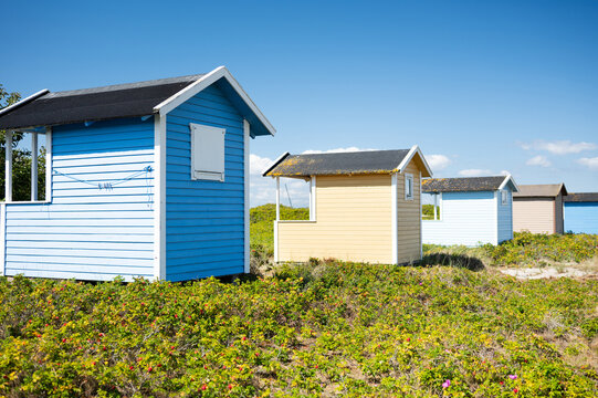 Row of bright colorful wooden beach houses on the Baltic Sea coast.