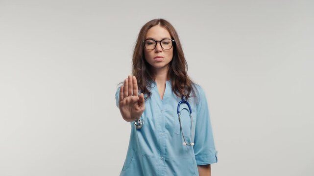 Serious Female Doctor Raising Open Palm In Stop Gesture, Physician Rejecting Unwanted Request, Setting Boundaries, Warning, Refusal, Prevention And Patient Safety
