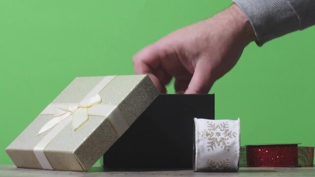 A person takes gift wrapping ribbons out of a box before the holiday. Different ribbons are shown one by one. This is a helpful step for holiday gift preparation.