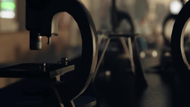 The workshop shows various machines lined up in a row. Tools are placed nearby. The scene has low light, creating shadows and highlights. The activity focuses on manufacturing processes.