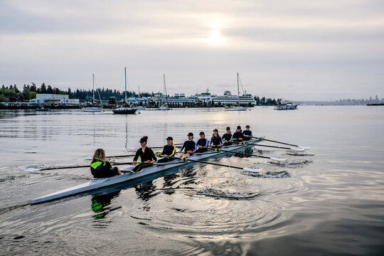 Eight-white person rowing team practicing on calm water in washington