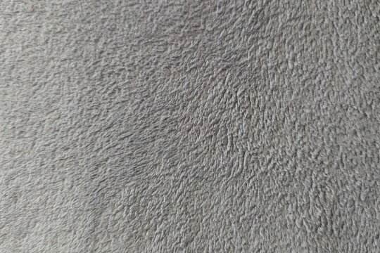 Surface texture close up shows a soft and fluffy gray material, highlighting its unique patterns and fibers