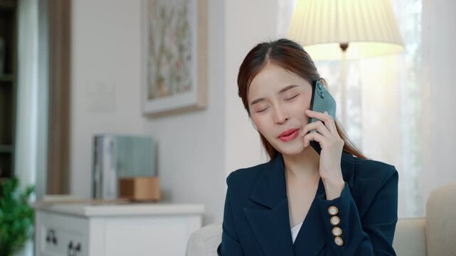Professional woman talking on a smartphone while sitting at home, representing communication, business calls, remote work, and modern lifestyle.

