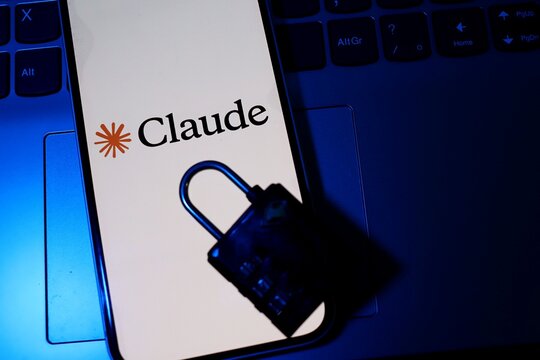Salvador, Brazil - August 12, 2026: Claude app logo on smartphone screen next to a padlock. AI security, digital credibility, and watermark concepts.