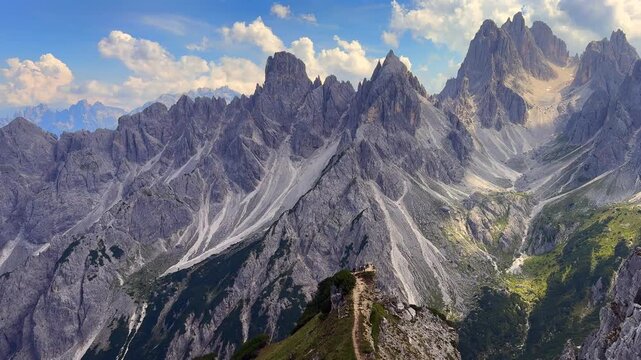 serene mountain landscape with rocky peaks and blue sky viewed from high vantage point in nature documentaries and travel videos. adventure content featuring majestic and dramatic scenery.