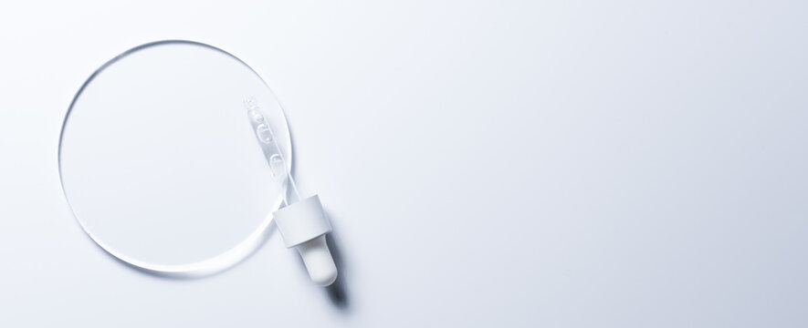 A glass circle on a blue background. A template for placing samples of cosmetics or medical products or food.