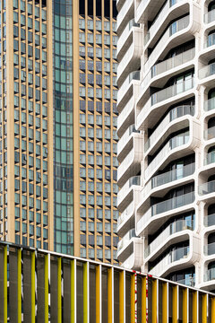 Curved towers press into a narrow frame as windows repeat in vertical bands, while facade contrast gives modern urban architecture a strong sense of density.