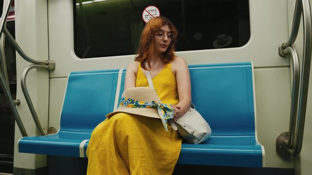 Woman in a yellow dress sitting on the Naples metro train