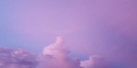 Fototapeta premium Dramatic purple sunset clouds over misty mountain landscape with soft light glow