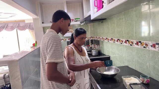 Grandmother teaching her grandson how to cook