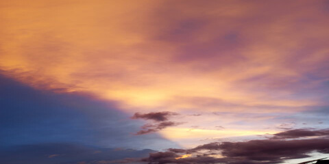 Fototapeta premium Dramatic sunset sky with vibrant orange and purple clouds over calm horizon