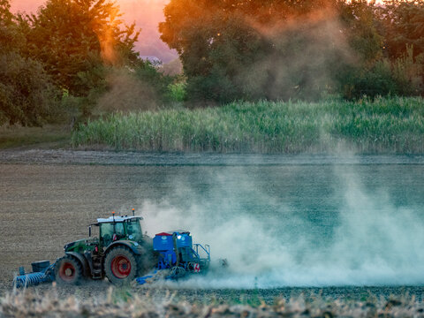 Traktor wirbelt Staub auf bei der Feldarbeit