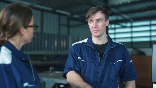 Male supervisor and female engineer planning factory operations on a laptop. Highlighting leadership, communication, and control.