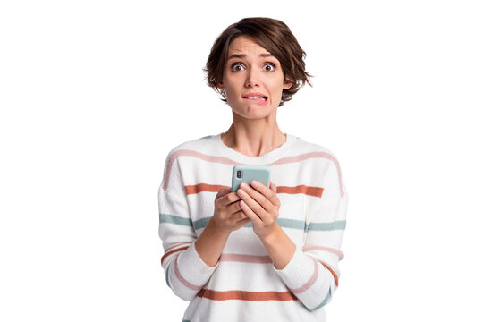Photo of cute sad young lady wear striped sweater holding modern gadget biting lip isolated grey color background
