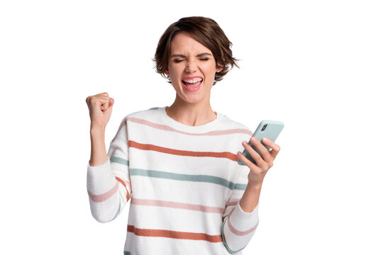 Photo of impressed lucky young woman dressed striped pullover holding modern device arm fist isolated grey color background