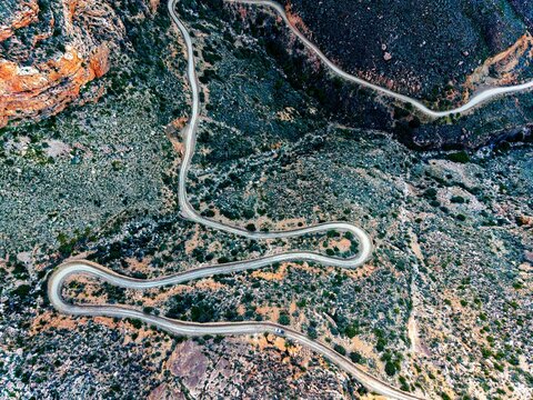 Aerial of mountain pass, dirt road winding from above