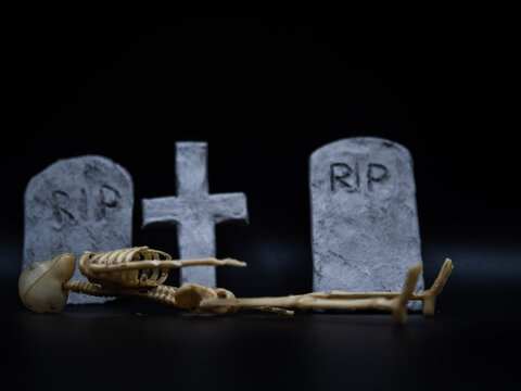 Skeleton in Halloween cemetery black background