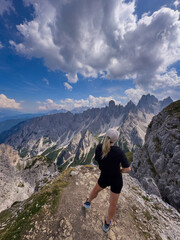 Obraz premium Young woman exploring hiking trail in Dolomites near Tre Cime Dolomites Italy