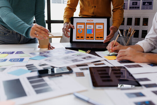 Ux ui designers collaborating on mobile application development, team analyzing wireframes and user interface concepts