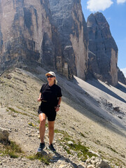 Obraz premium Young woman exploring hiking trail in Dolomites near Tre Cime Dolomites Italy
