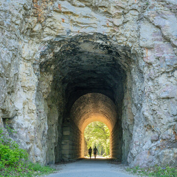 Silhouette of a couple walking through a tunnel on Katy Trail near Rocheport, Missouri. The Katy Trail is 237 mile bike trail converted from an old railroad.