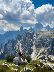 Obraz premium Young woman exploring hiking trail in Dolomites near Tre Cime Dolomites Italy