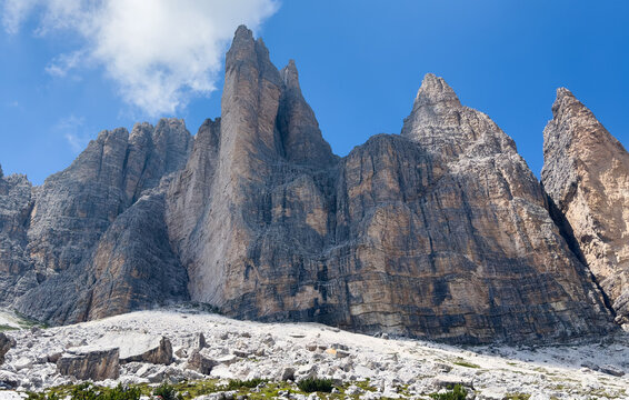 panorama of Tre Cime in the Dolomites, highlighting jagged cliffs and green meadows 