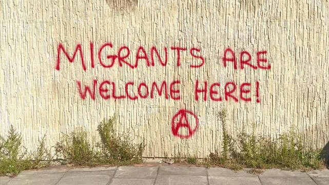 Brighton, East Sussex - August 12th 2026: Migrants are welcome here message Graffiti on wall near Duke's Mound