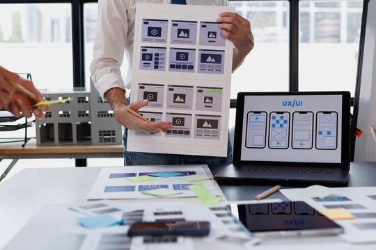 Ux ui designer team collaborating on wireframes and app user interface development, discussing mobile application design