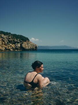woman sat in the sea in Sardinia