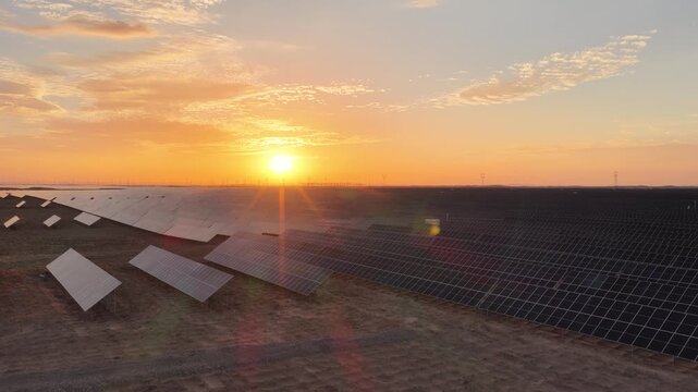 Stunning Sunset over Vast Solar Panel Farm in Remote Sandy Desert Landscape