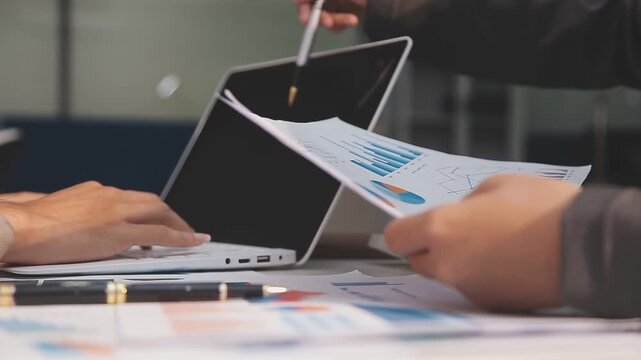 Business partnership coworkers using a tablet to analysis graph company financial budget report and cost work progress and planning for future in office room.