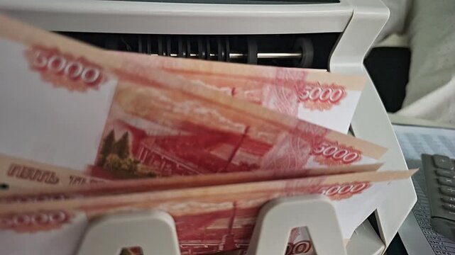 Counting cash at a bank in Russia during the afternoon