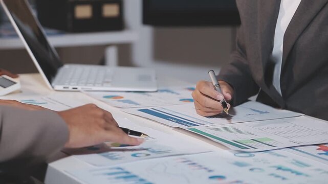 Business partnership coworkers using a tablet to analysis graph company financial budget report and cost work progress and planning for future in office room.