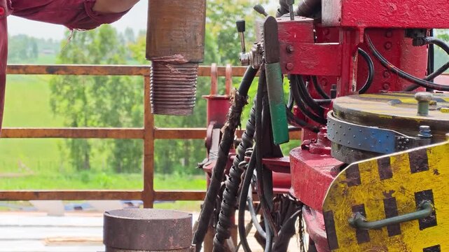 Operating power tong, torque machinery, to make connection of the drill pipe in the oil drilling operation. Heavy industrial working scene footage. close-up.