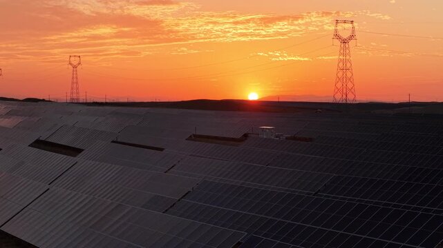 Stunning Sunset over Vast Solar Panel Farm in Remote Sandy Desert Landscape