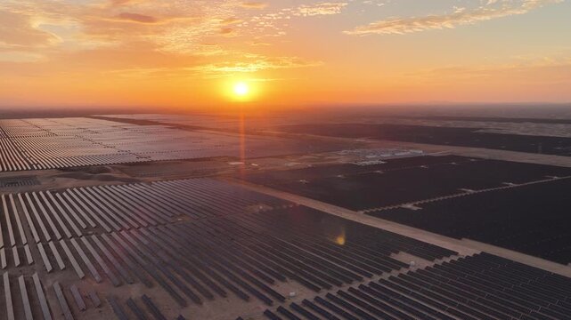 Stunning Sunset over Vast Solar Panel Farm in Remote Sandy Desert Landscape