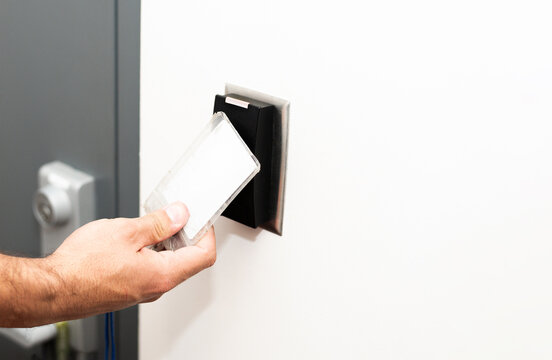 Hand using access card to unlock secure door