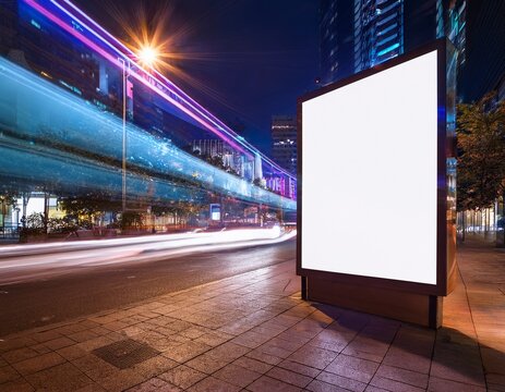 blank glowing billboard display on a neon lit urban street at night