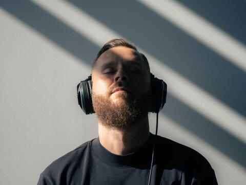 Man Listens to Music With Closed Eyes Indoors