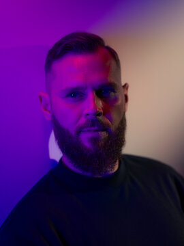 Thoughtful man portrait in purple light 