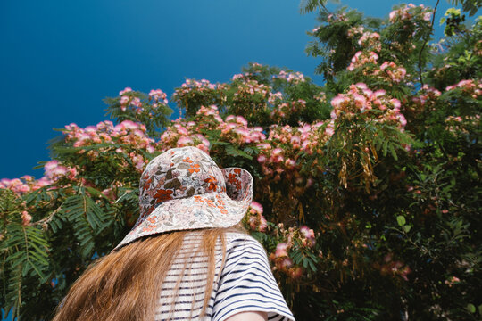 Girl admiring blooming pink tree