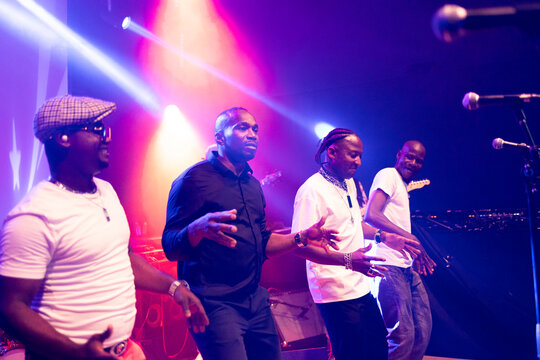 Group of male performers dancing live music concert